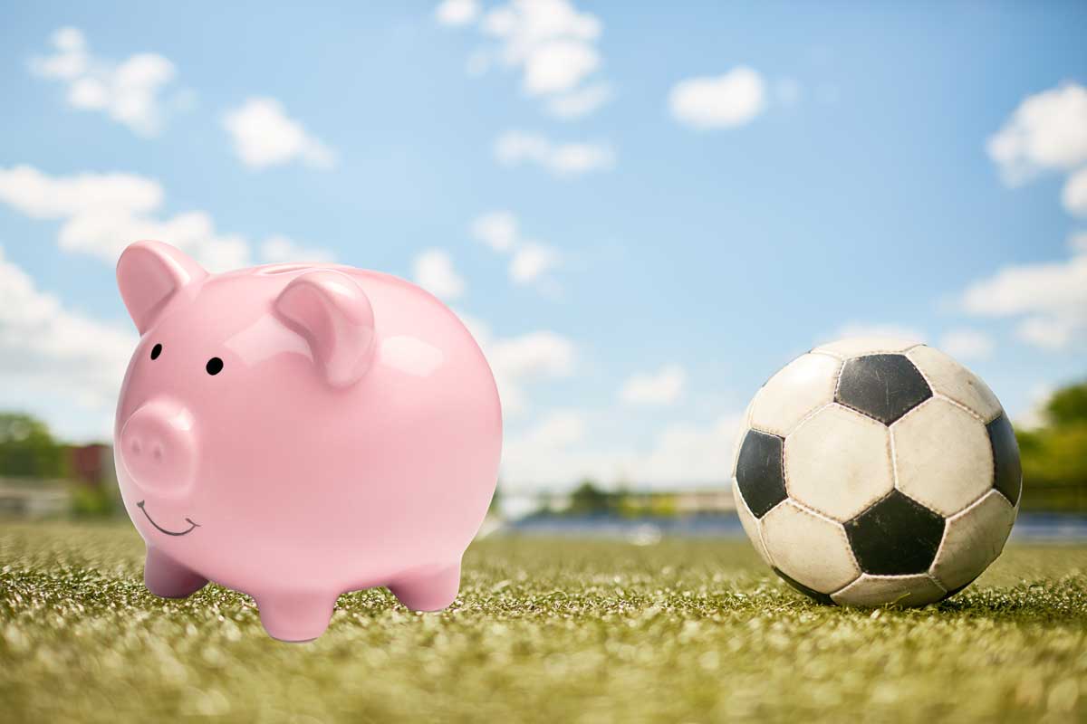A piggy bank next to a football, symbolizing the importance of sports betting bankroll management.