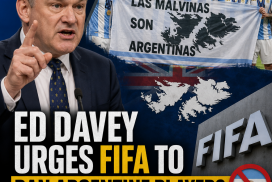 Ed Davey speaks passionately at a podium, urging FIFA to ban Argentine players over the Falklands banner issue.