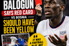 Folarin Balogun gestures passionately during a football match, disputing a red card decision.