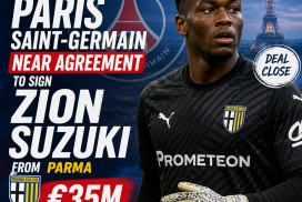 Paris Saint-Germain goalkeeper Zion Suzuki in action, wearing a green jersey and gloves.