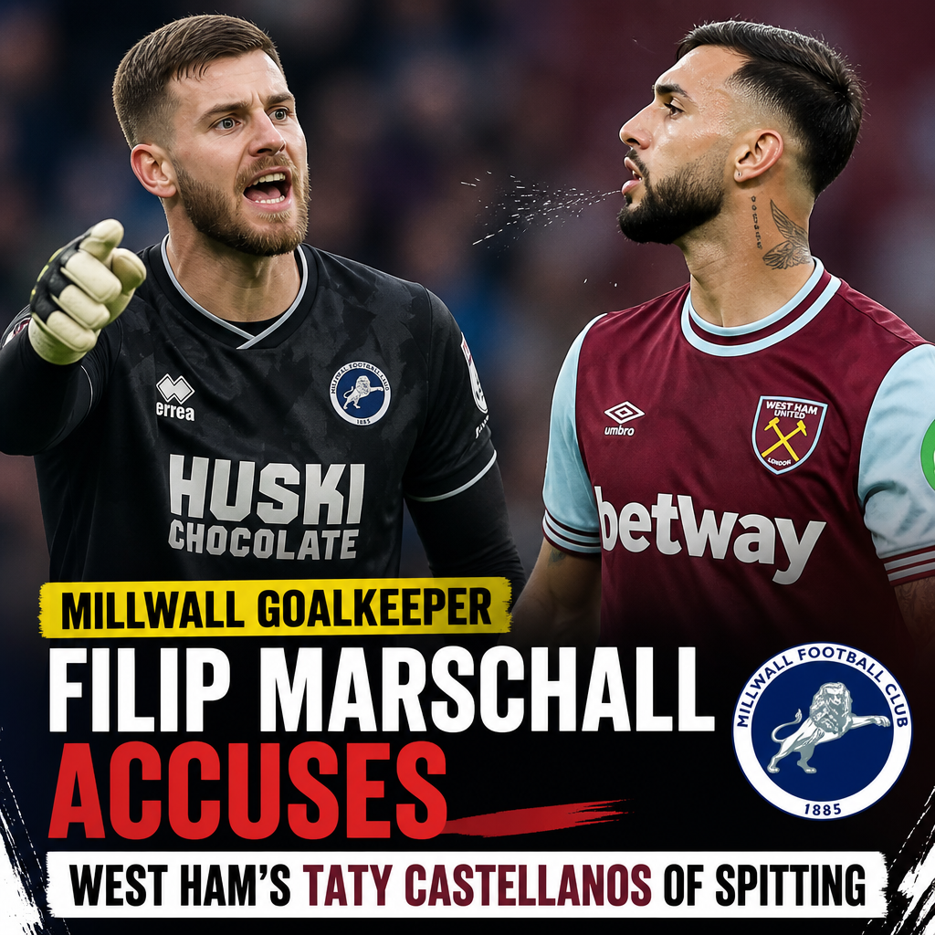 Millwall goalkeeper Filip Marschall gestures angrily accusing West Ham's Taty Castellanos of spitting during a match.