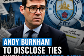 Portrait of Andy Burnham speaking at a microphone with a blurred blue background.