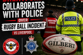 Police officers and Brentford staff talking on the football pitch during a match against Liverpool.